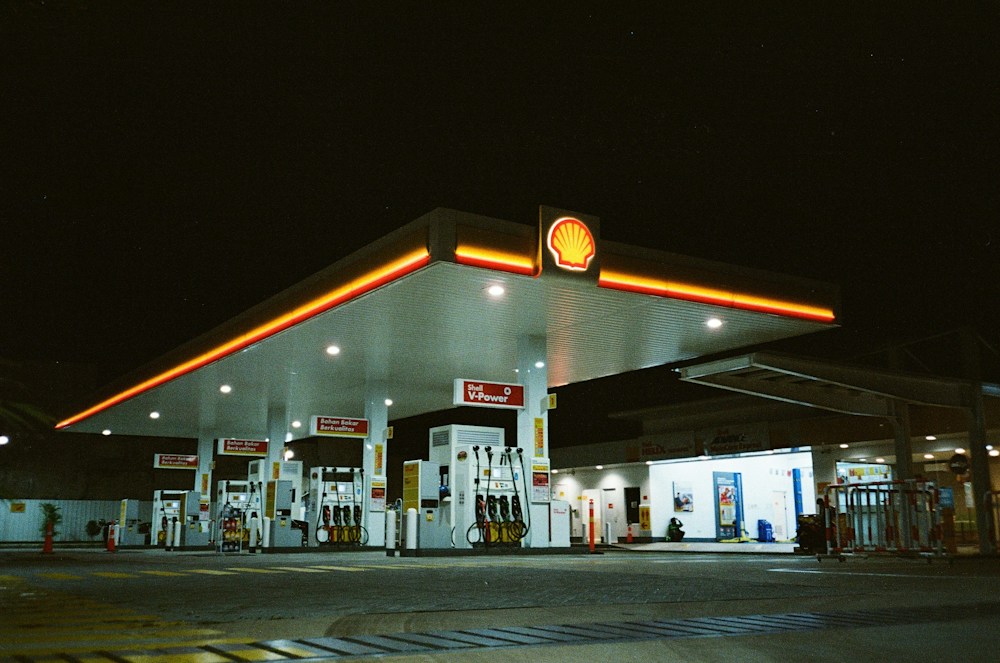 A warmly lit modern filling station at night